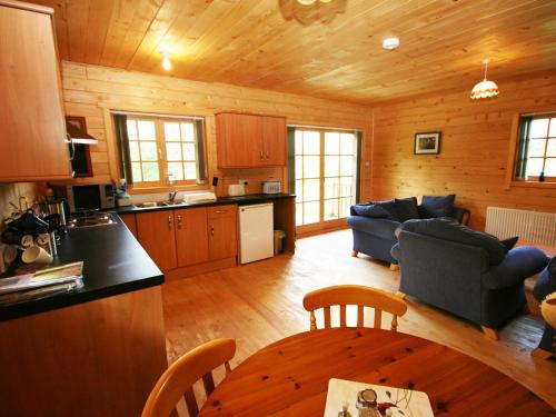 a kitchen and a living room with a table and chairs at Auchenhill Lodge in Lochend