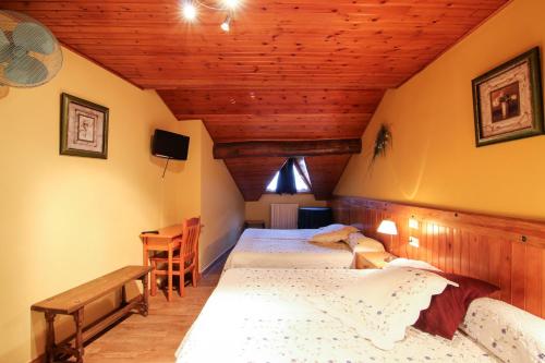 a bedroom with two beds in a attic at Roch Hotel in Altrón