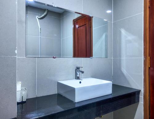 a bathroom with a white sink and a mirror at Bolyno Skyline Hotel in Phnom Penh