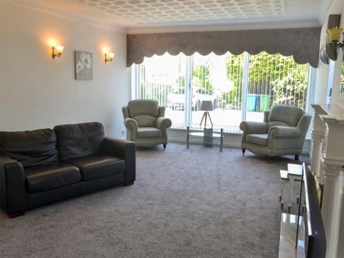 a living room with a couch and two chairs at Dunpullin in Bedlington