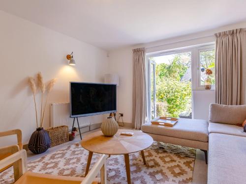 a living room with a couch and a tv at Pentreath 4 in St Ives