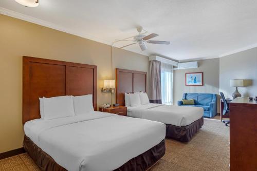 a hotel room with two beds and a chair at Comfort Inn & Suites Ocean Shores in Ocean Shores
