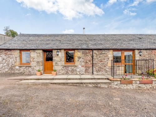 a stone house with a porch and a door at The Steading Cottage in Glenfarg