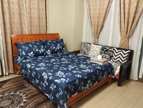 a bedroom with a bed with a blue comforter at The Layover Condotel ,Palm Tree two Villas ,cluster 2 - unit 7q , New Port Boulevard , Newport City ,NAIA Terminal 3 , Pasay City , Philippines in Sampong