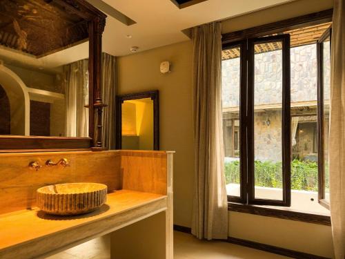 a bathroom with a sink and a large window at Anket De' River Mui Ne resort in Mui Ne