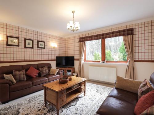 a living room with a couch and a coffee table at Holly Cottage in Gorstan