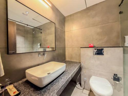 a bathroom with a sink and a toilet and a mirror at Zip By Spree Hotels Chinchwad in Chinchwad