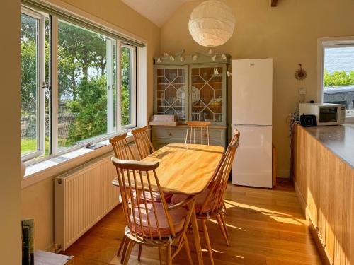 a kitchen with a table and chairs and a refrigerator at The Green in Lochranza