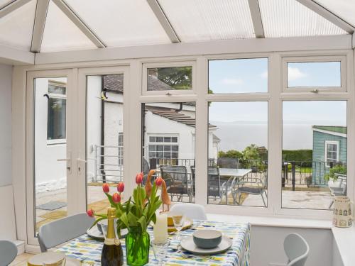 a conservatory with a table and chairs and a dining room at Seacliffe in Kildonan