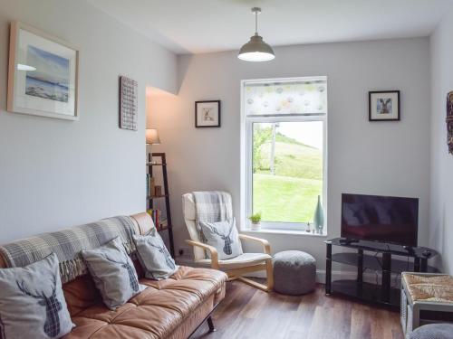 a living room with a couch and a window at Seacliffe in Kildonan