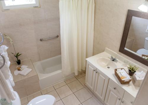 y baño con lavabo, bañera y aseo. en Aruba Surfside Marina en Oranjestad
