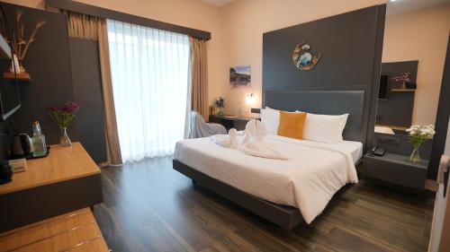 a bedroom with a large white bed in a room at Surf and Sand in Candolim