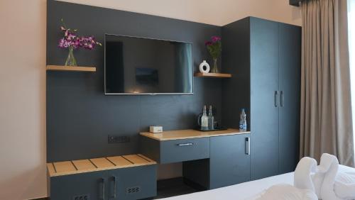 a bedroom with a desk and a tv on a wall at Surf and Sand in Candolim
