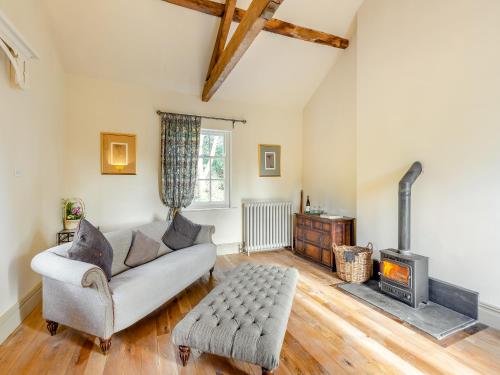 a living room with a couch and a fireplace at Apartment At Llanerchydol Hall in Welshpool