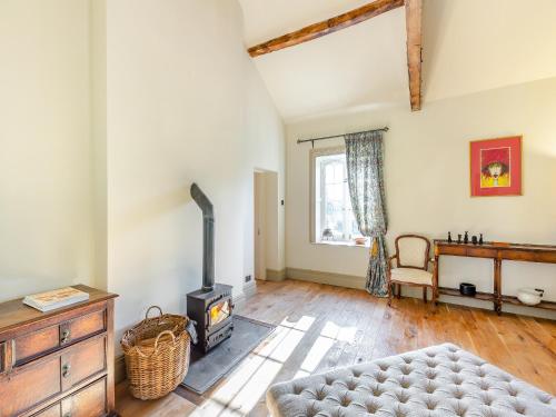 a living room with a wood stove and a couch at Apartment At Llanerchydol Hall in Welshpool