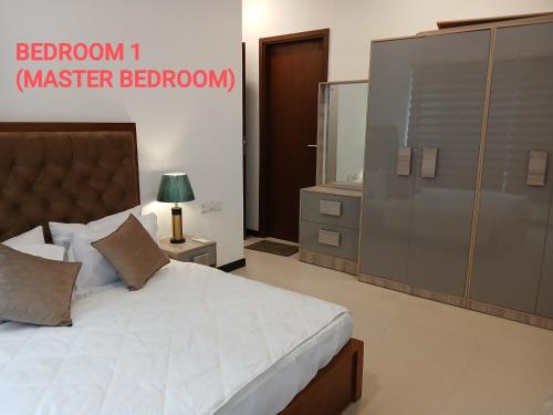 a bedroom with a bed with a dresser and a mirror at Trizen Colombo Luxury 3 Bedroom Apartment in Colombo