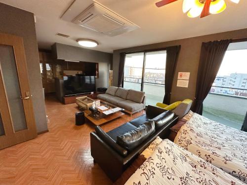 a living room with a couch and a tv at Hotel EL Utsunomiya 7 free parking in Utsunomiya