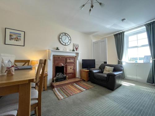 a living room with a couch and a fireplace at Pine Cottage - Dalcross in Dalcross