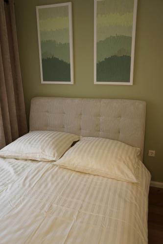 a bed in a bedroom with two pictures on the wall at Cozy apartment in Irrel in Irrel