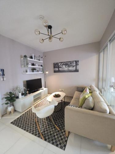 a living room with a couch and a table at FavStay Ramkhamhaeng, Stylish 1BR Bangkok in Bangkok