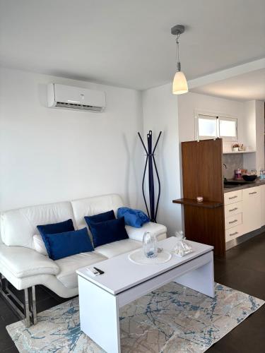 a living room with a white couch and blue pillows at Chalet Barceló Rocher in Cala d´Or