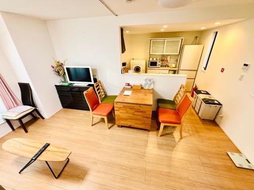 a living room with chairs and a table and a television at 东京池袋城市住宿-Ikebukuro Urban Stay in Tokyo