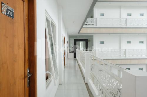 a hallway of a building with white walls and a wooden door at Sazara Hotel Batu in Selecta