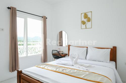 a bedroom with a bed with a large window at Sazara Hotel Batu in Selecta