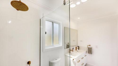 a white bathroom with a sink and a mirror at Red Hill Cabin #1 Walcha in Walcha