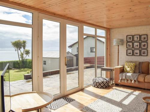 a living room with sliding glass doors and a couch at Southcroft Lodge in Whiting Bay