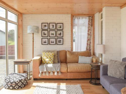 a living room with a couch and a table at Southcroft Lodge in Whiting Bay