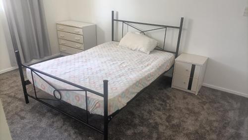 a small bedroom with a bed and a night stand at Suthar's Home in Wellington