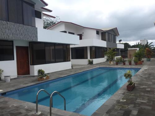 une villa avec une piscine en face d'une maison dans l'établissement Casa en Tonsupa, à Tonsupa
