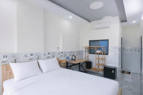 a white bedroom with a bed and a kitchen at Tâm An Hotel 2 in Nhơn Trạch
