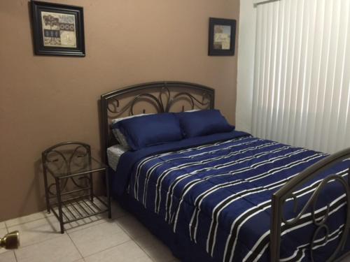 a bedroom with a bed with blue sheets and a chair at Beautiful 2 bedroom 1 bath in Tamuning