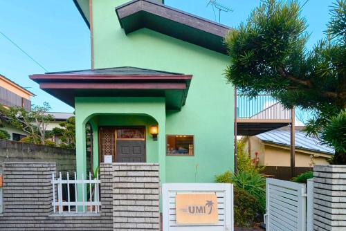 a green house with a sign in front of it at 真鶴貸別荘 海 in Manazuru
