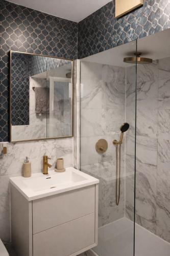 a bathroom with a white sink and a shower at Central London Apartment in London