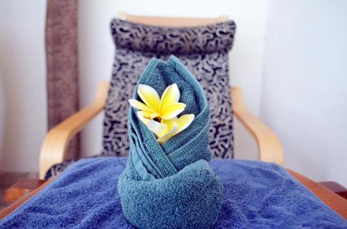 a blue towel with a flower on top of a table at Jas Boutique Villas in Seminyak