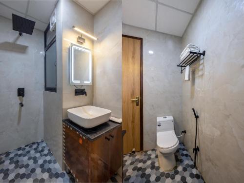 a bathroom with a white toilet and a sink at Hotel Elite Clark in Noida