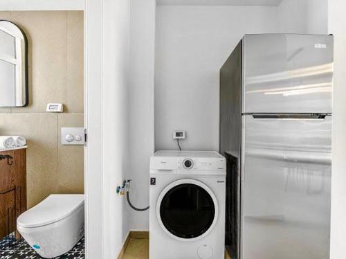 a kitchen with a washing machine and a refrigerator at Redsearent suite with pool view in Eilat