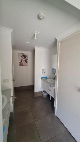 a bathroom with a sink and a toilet in a room at Hervey Bay Flashpackers in Hervey Bay