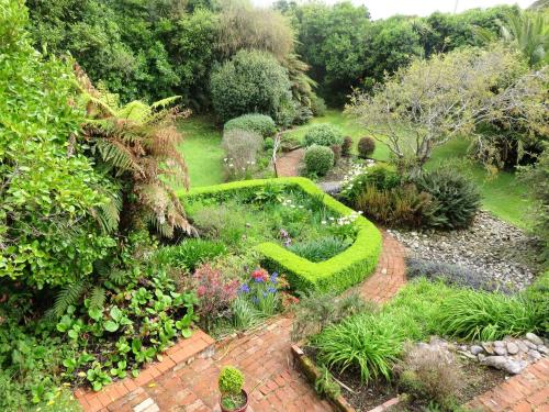 a garden with a brick path with plants and flowers at Awatuna Homestead in Awatuna