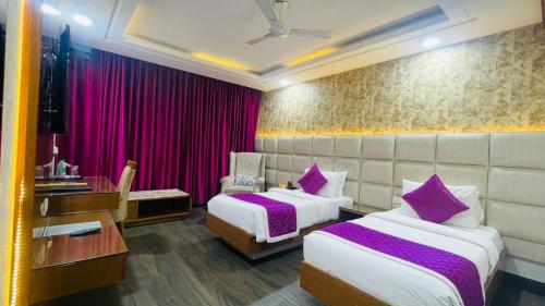 a hotel room with two beds and a desk at HOTEL JD HEAVENS in Jhajjar