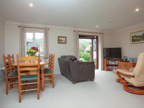 a living room with a table and chairs and a television at Gull Cottage in Falmouth