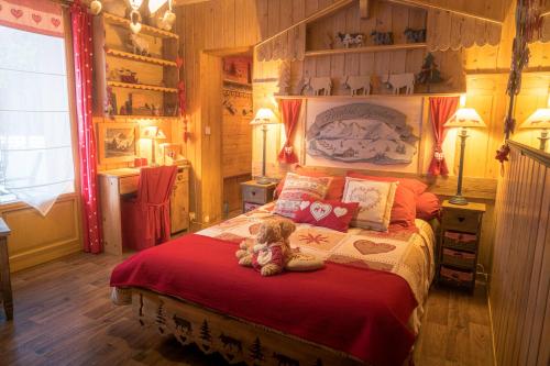 a teddy bear sitting on a bed in a bedroom at Chalet la Colombière in Sainte-Agnès
