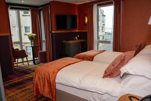 a hotel room with two beds and a window at Albert Hotel in Kirkwall