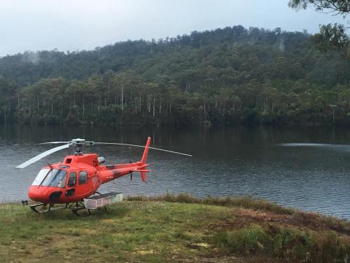 a red helicopter parked next to a body of water at Tullah Lakeside Lodge in Tullah