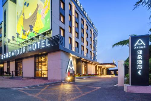 a hotel building with a sign in front of it at Dalian Airport Yingke Road Atour Hotel in Dalian