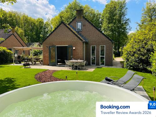 a backyard with a hot tub and a house at 6pers Boshuis -Hottub Jacuzzi- 'De Groene Specht' in Ewijk