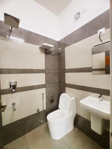 a bathroom with a toilet and a sink at Chikkary's Inn in Munnar